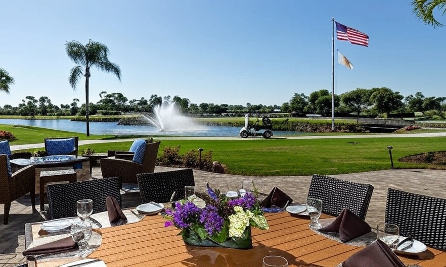 Bear's Paw Country Club in Naples FL patio view with US flag and golf cart via Grok