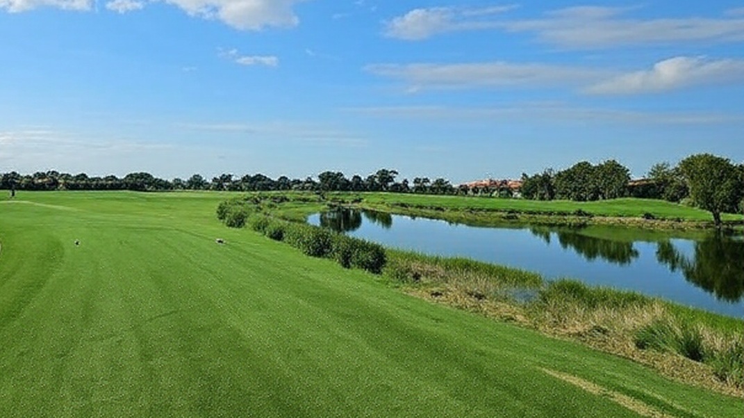 Heritage Bay Golf & Country Club in Naples Florida fairway view with water on right via Grok
