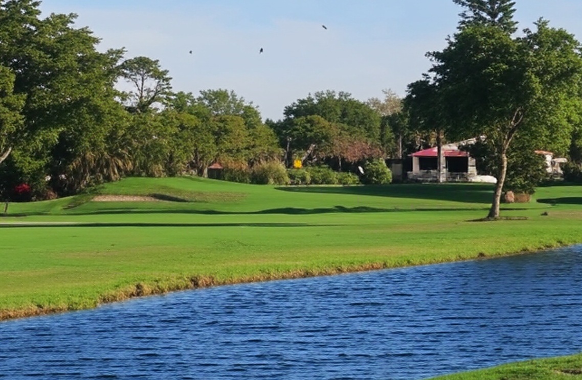 Lakewood Country Club in Naples Florida fairway with water view via Grok<br />

